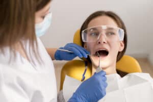 dentist checking patient mouth for emergency tooth extractions