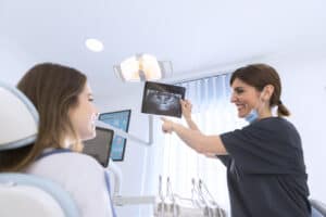 Dentist showing Dental X-Rays to patient